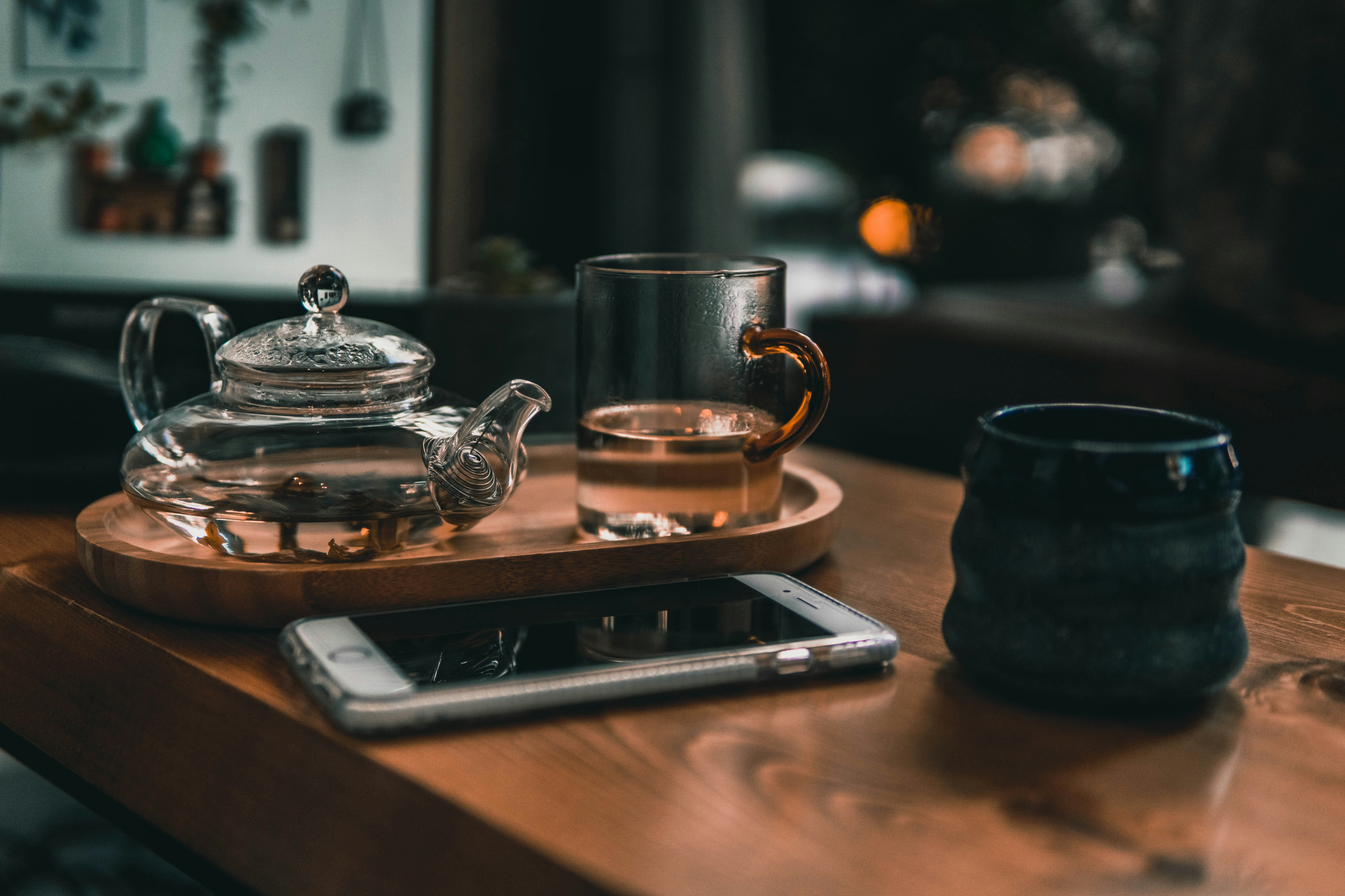 clear glass teapot on brown wooden tray